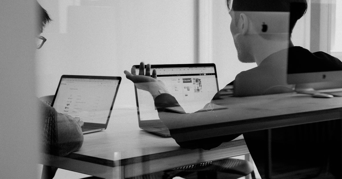 Advisor consulting a business owner client at a desk in a modern office setting