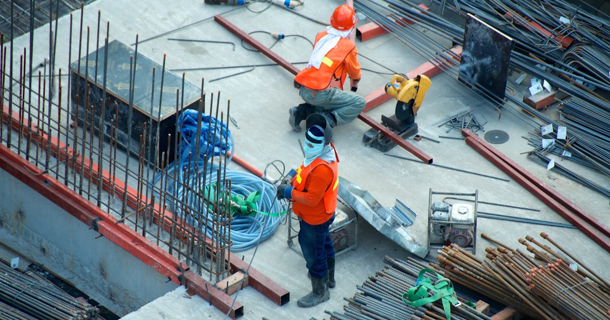 Well-dressed construction supervisor on a modern job site, reviewing the project with confidence